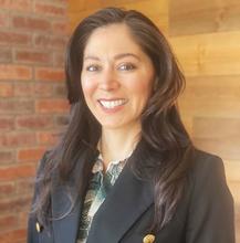Woman with long dark hair in a business suit